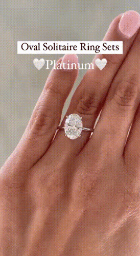 An Oval Solitaire Ring Set In Platinum Is On A Woman 'S Finger GIF