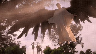 Angel Statue Flying Over City GIF