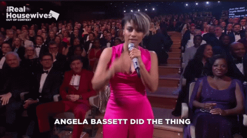 Angela Bassett Sings Into A Microphone In Front Of A Crowd GIF