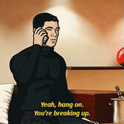 Archer Is Sitting On A Couch Talking On A Cell Phone GIF