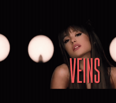 Ariana Grande Is Making A Funny Face In A Dark Room With Lights Behind Her . GIF