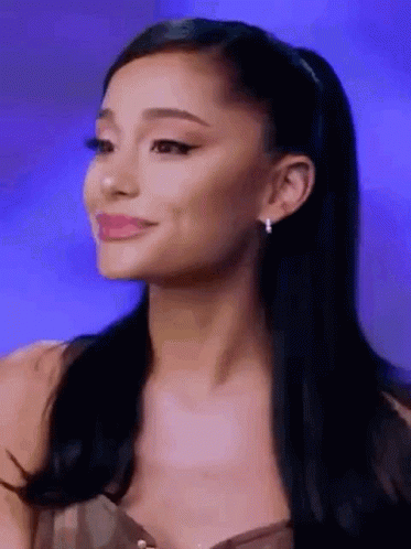 Ariana Grande Is Smiling And Looking At The Camera While Wearing Earrings . GIF