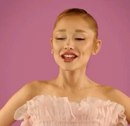 Ariana Grande Is Wearing A Pink Strapless Dress And A Bun . GIF