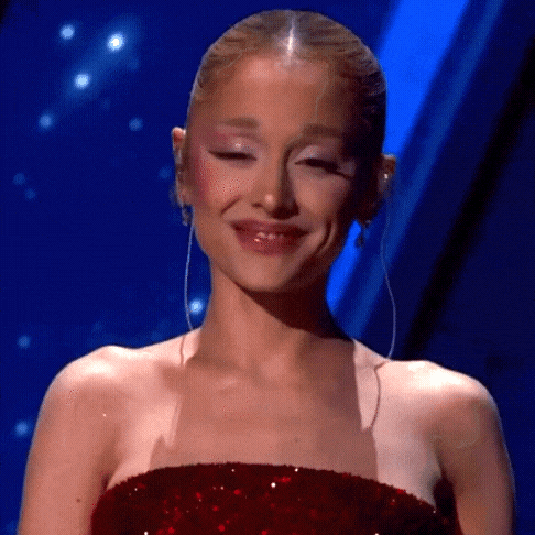 Ariana Grande Is Wearing A Red Sequined Dress And Earrings And Smiling . GIF