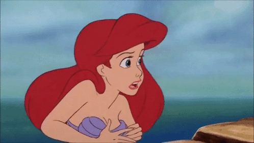 Ariel From The Little Mermaid Is Sitting On A Rock In The Ocean Looking At Something . GIF