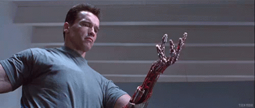 Arnold Schwarzenegger Is Holding A Bloody Robotic Arm In Terminator 2 Judgment Day . GIF