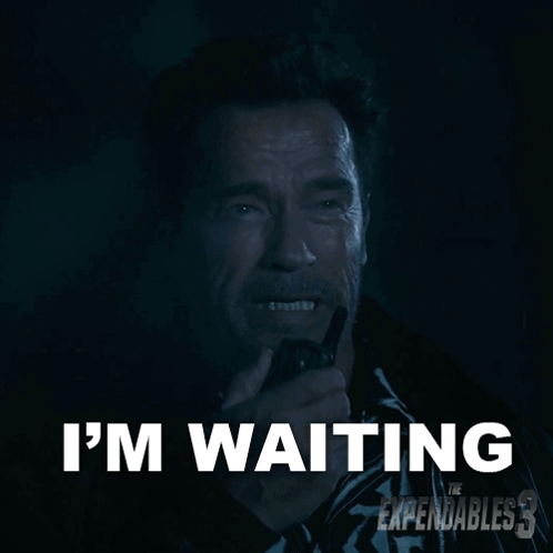 Arnold Schwarzenegger Is Holding A Walkie Talkie And Says " I 'M Waiting " In White Letters GIF