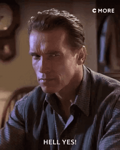Arnold Schwarzenegger Is Sitting At A Table With A Clock In The Background . GIF