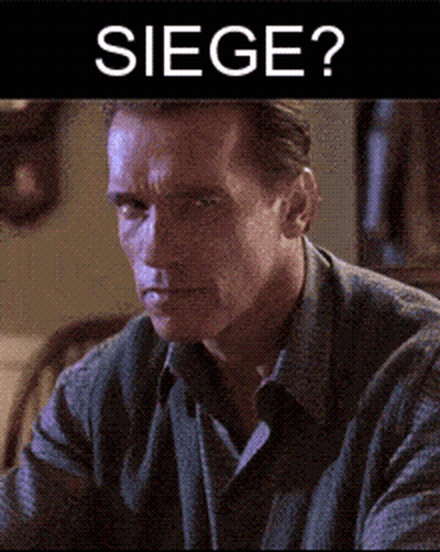 Arnold Schwarzenegger Is Sitting In Front Of A Sign That Reads Siege GIF