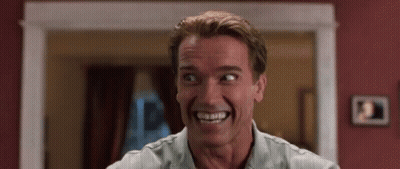 Arnold Schwarzenegger Is Smiling And Making A Funny Face In A Movie . GIF