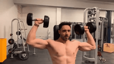 Arnold Schwarzenegger Lifting Dumbbell In Gym GIF