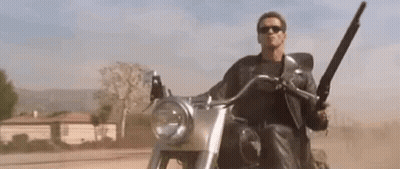 Arnold Schwarzenegger Riding Motorcycle With Shotgun GIF