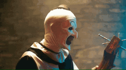 Art The Clown Looks At Wood With Nails GIF