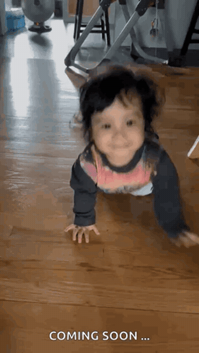 Baby Crawling On Wooden Floor Saying Coming Soon GIF