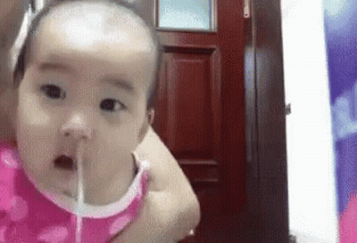 Baby Drinking Water From Straw In Woman's Arms GIF