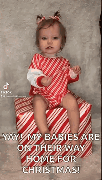 Baby Girl Sitting On Candy Cane Gift GIF