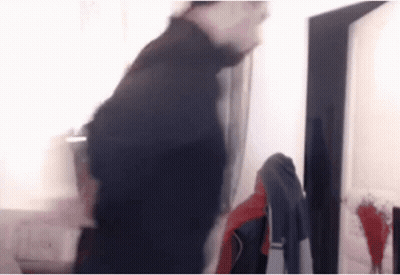 Baby Girl Standing By Wooden Table Looking At Camera GIF