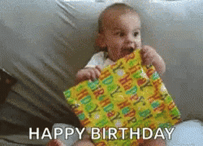 Baby Holding Birthday Present Saying Happy Birthday GIF