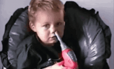 Baby Holding Toy Drill In Mouth In High Chair GIF