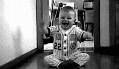 Baby In Baseball Uniform Sitting On Floor Black And White GIF