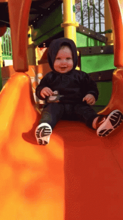 Baby In Black Hoodie On Orange Slide GIF
