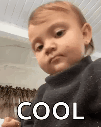 Baby In Black Sweater Making Funny Face Saying Cool GIF