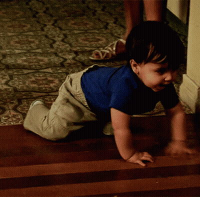 Baby In Blue Shirt Crawling On Wooden Floor GIF