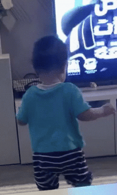Baby In Blue Shirt In Front Of TV With Number 5 GIF