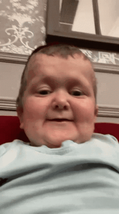 Baby In Blue Shirt Making Funny Face GIF