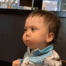 Baby In Blue Shirt Sitting In Chair Making Funny Face GIF