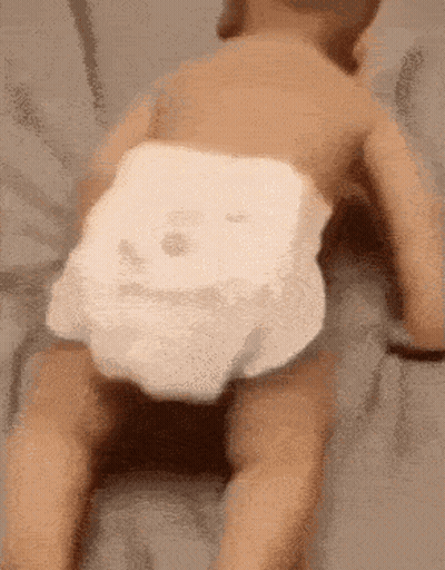 Baby In Diaper Crawling On Back On Bed GIF