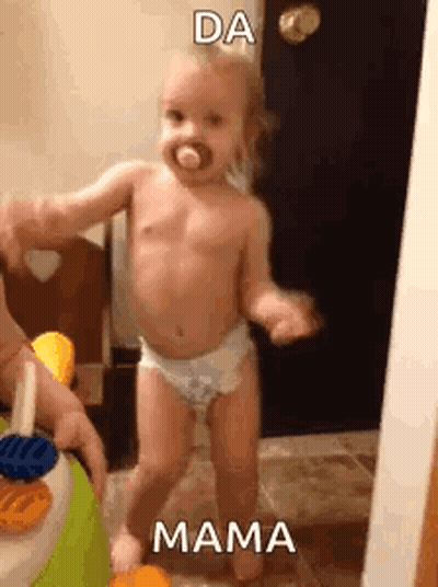 Baby In Diapers Dancing With Person Holding Toy GIF