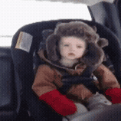 Baby in Furry Hat and Red Mittens in Car Seat
