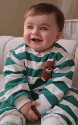Baby In Green And White Striped Shirt Holding Teddy Bear GIF