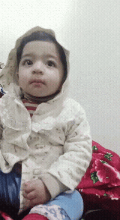 Baby In Hooded Jacket Sitting On Red Blanket GIF