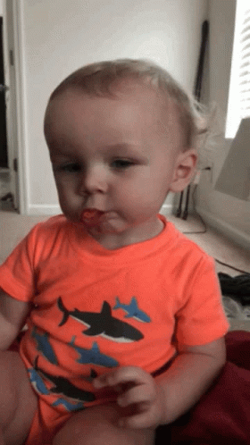 Baby In Orange Shark Shirt Eating GIF