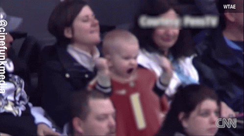 Baby In Red Jersey Number 1 Held By Woman GIF