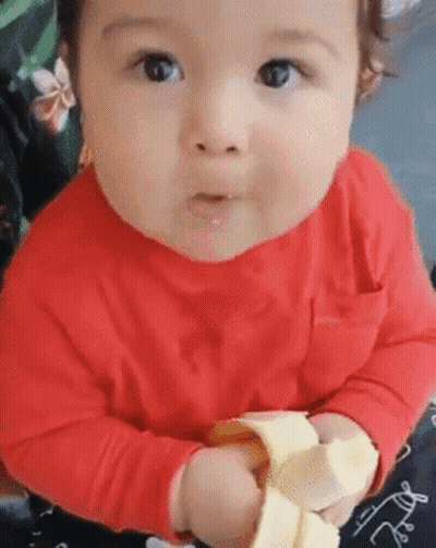 Baby In Red Shirt Eating Banana Peel GIF