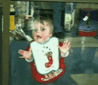 Baby In Reindeer Bib Looking Out Window GIF