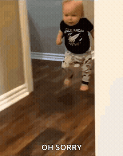 Baby in Space Racer Shirt Walking on Wooden Floor
