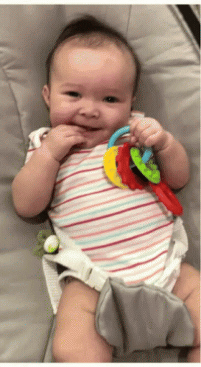 Baby In Striped Shirt Holding Rainbow Teething Toy GIF