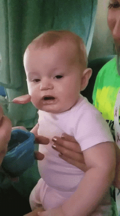 Baby In White Shirt Being Fed By Woman GIF