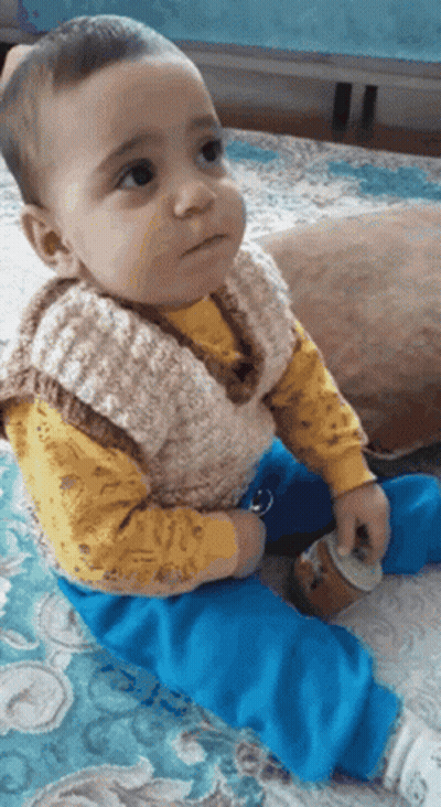 Baby In Yellow Shirt Blue Pants On Bed GIF