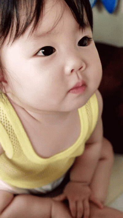 Baby In Yellow Tank Top Looking Up GIF