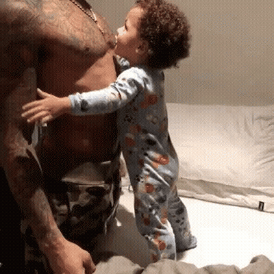 Baby Kissing Man's Chest On Bed GIF