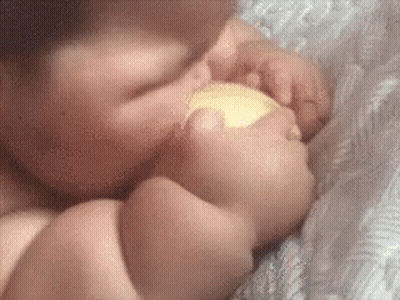 Baby Laying On Bed Eating Food GIF