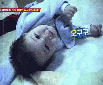 Baby Laying On Bed With Recorder GIF
