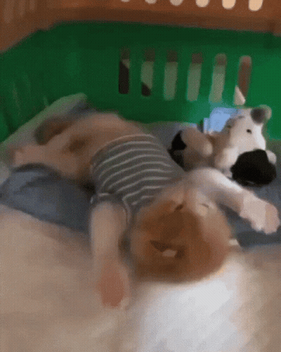Baby Lying On Bed With Stuffed Animal GIF