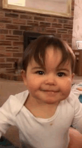 Baby Making Funny Face By Fireplace GIF