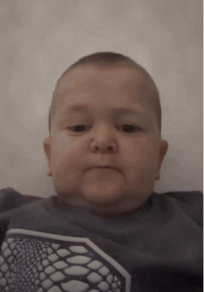 Baby Making Funny Face In Gray Shirt GIF